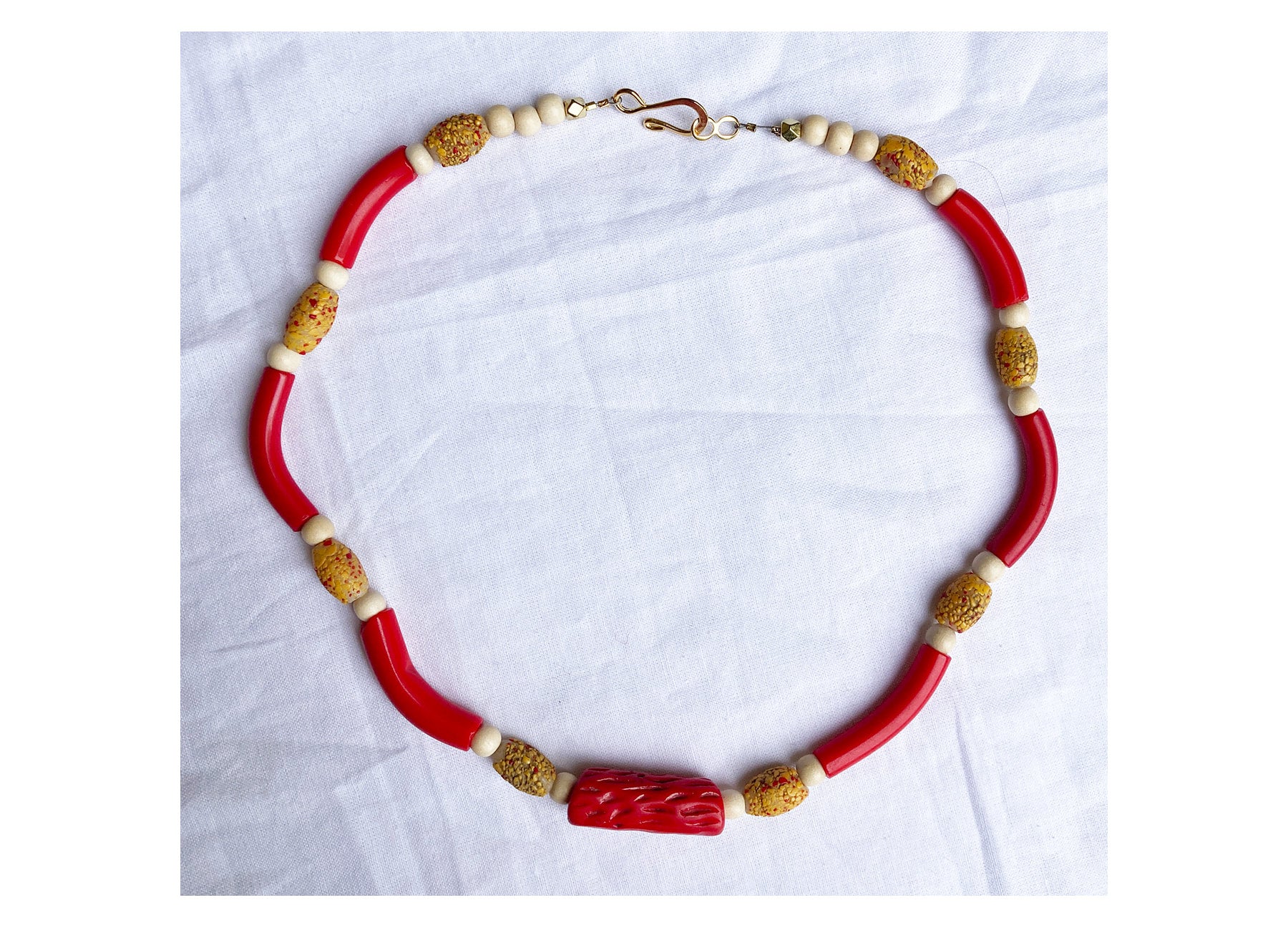 Single strand necklace of red antique Czech curved glass tube beads,  antique Venetian textured and crackled yellow and red oval shaped trade  beads, biconal coconut wood beads, with central rarely. seen antique